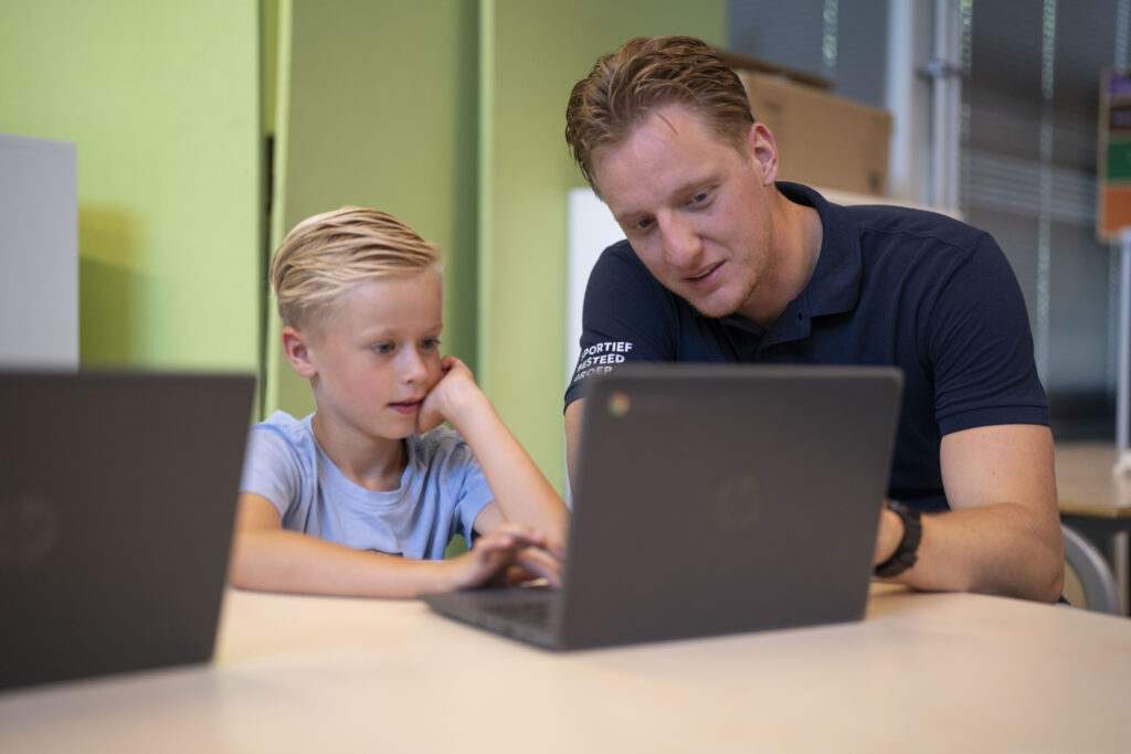 Man wijst iets aan op de computer